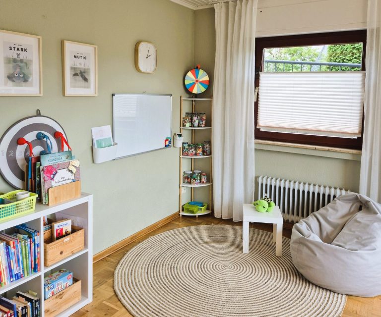 Bild des Therapiezimmers mit Tafel, Bücherregal und Sitzsack.